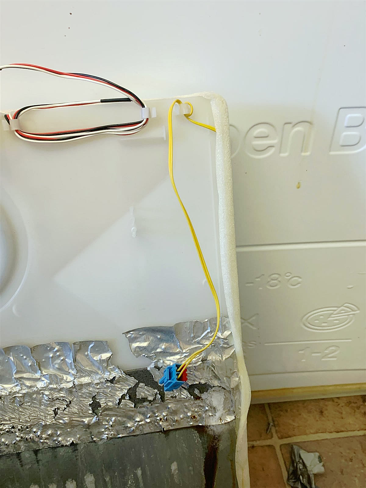 Fridge back panel open, sensor wiring on the evaporator